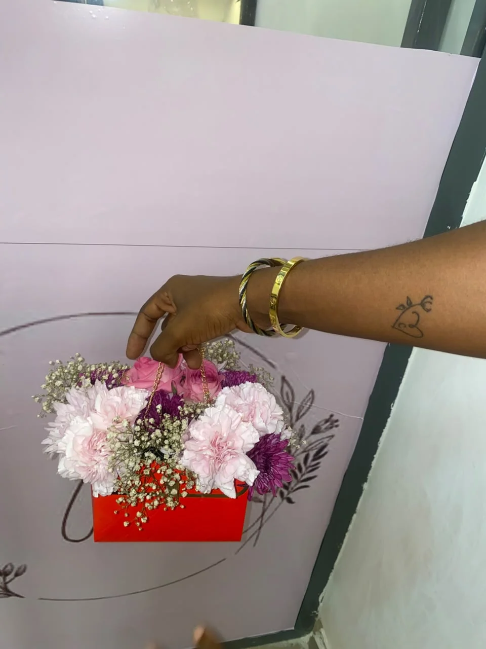 Hand holding a floral box arrangement from Alexandra's Floral